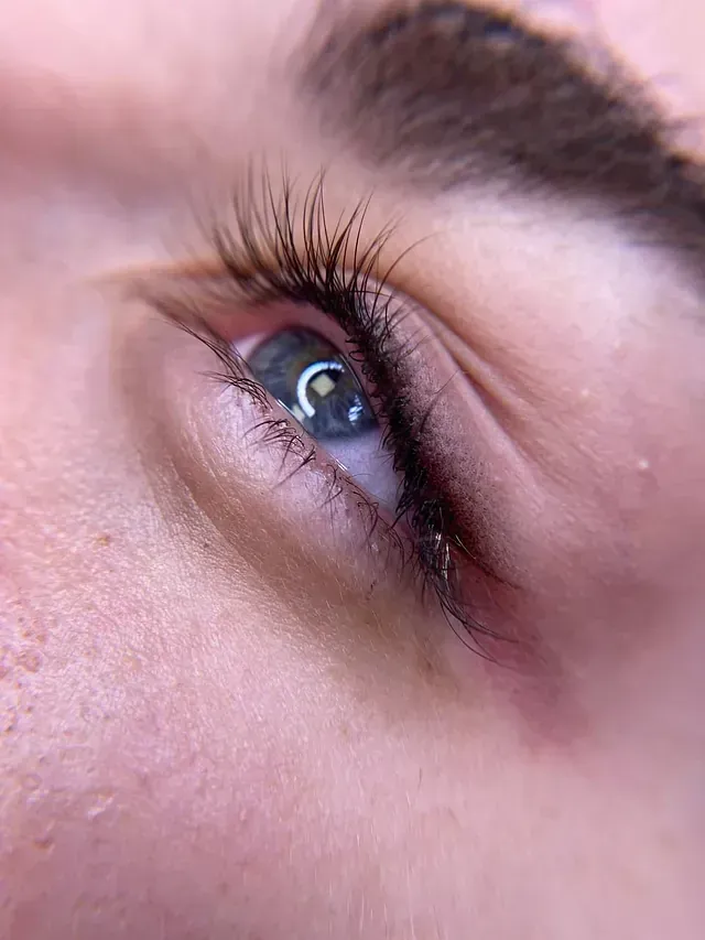 Un primer plano del ojo de una mujer con pestañas largas.