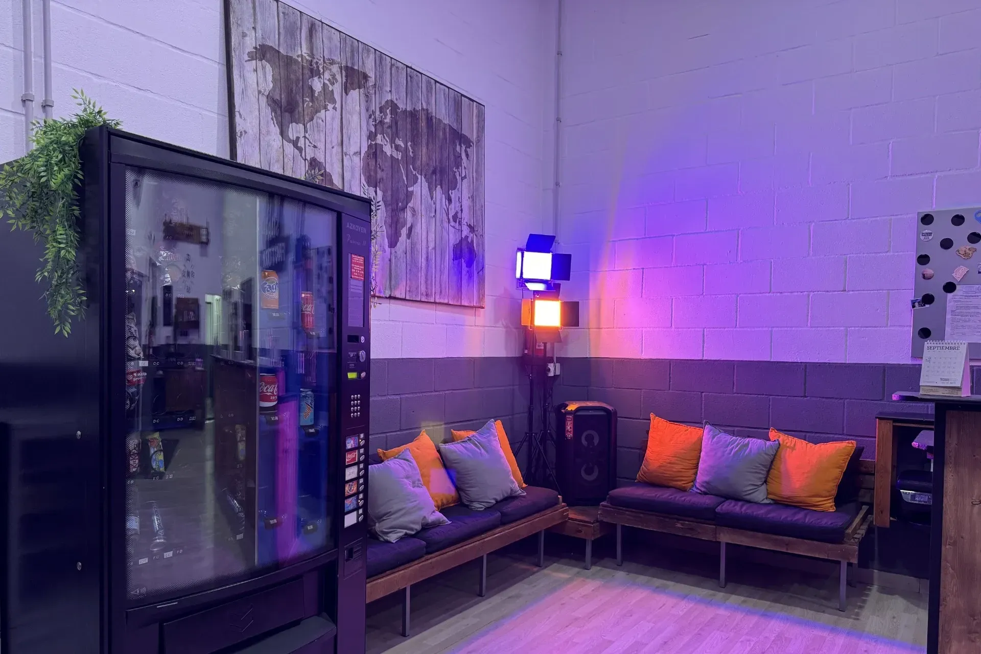 Una sala de espera con una máquina expendedora y un sofá.