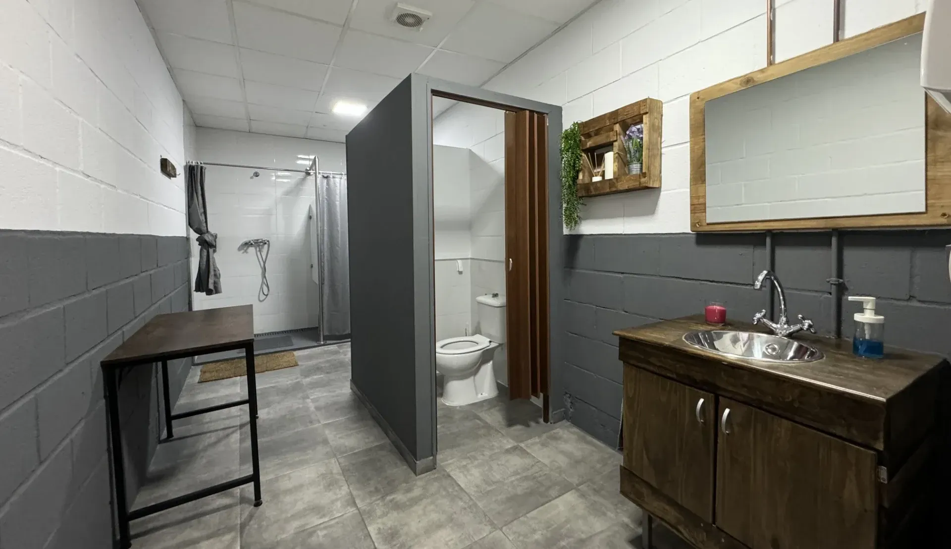 Un baño con lavabo, inodoro, ducha y espejo.