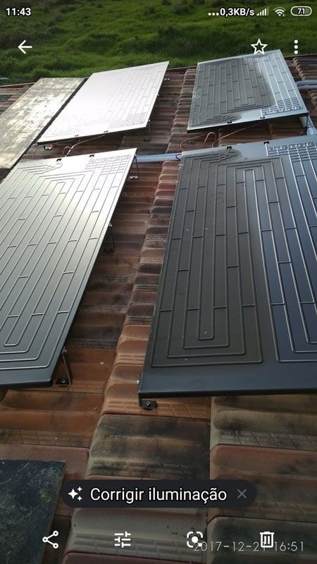 Painéis solares para aquecimento de água instalados em um telhado de telhas.