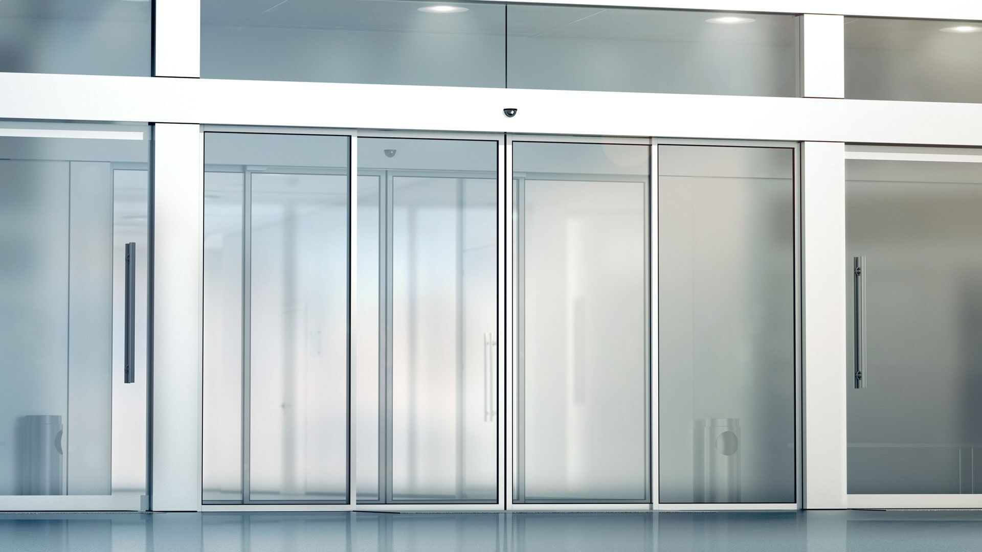 Portas de vidro deslizantes automáticas na entrada de um edifício moderno.