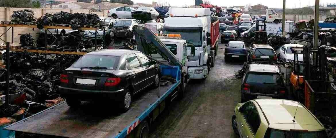 Una grúa transporta un automóvil encima de un camión de plataforma.
