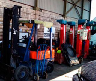 Una fila de carretillas elevadoras están estacionadas en un garaje.