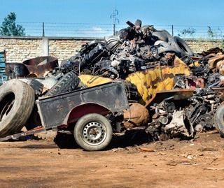 Un camión está parado en una pila de chatarra.