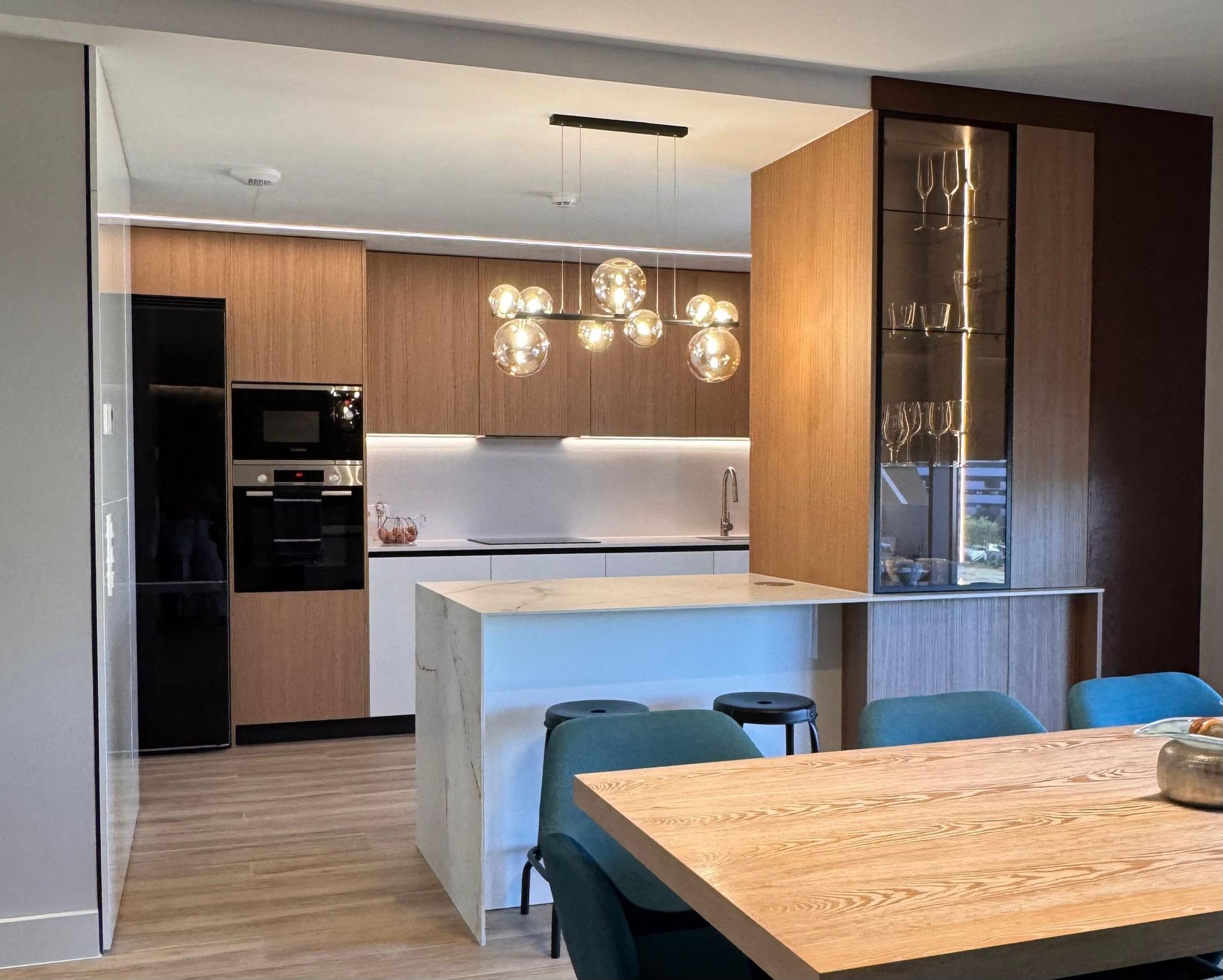 Cocina blanca moderna con encimeras, electrodomésticos y accesorios negros.