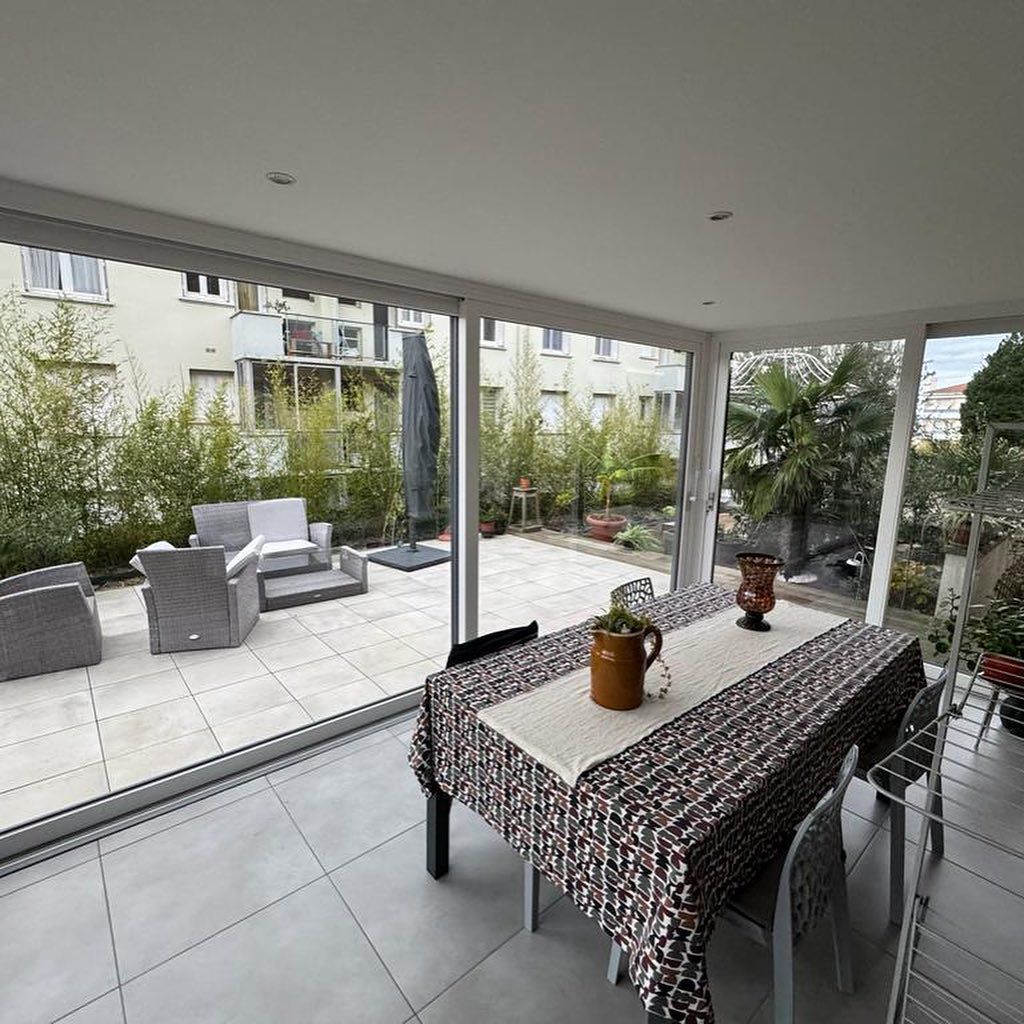 Une véranda avec une table à manger à motifs.