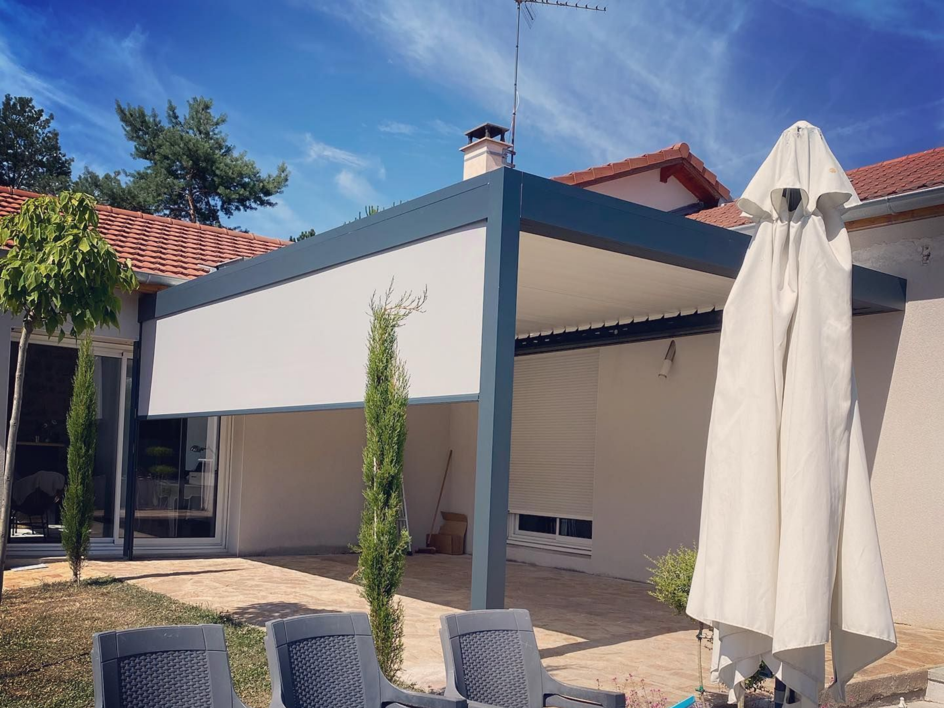 Une pergola appuyée sur une façade.