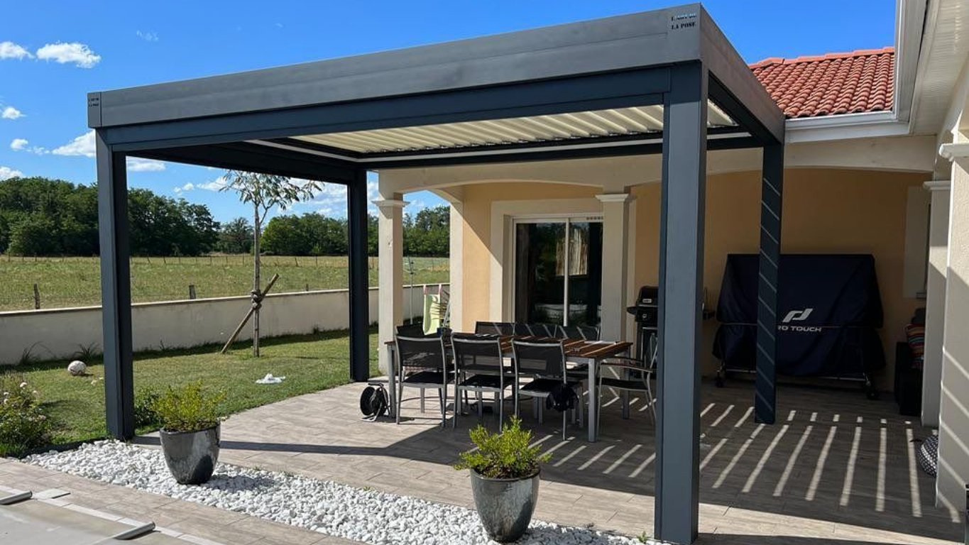 Une pergola en métal sombre surplombe un patio.