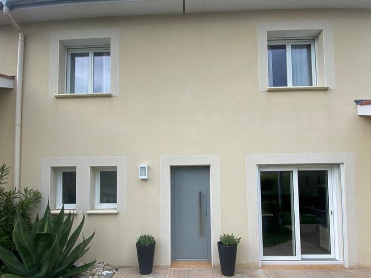 Une maison avec une porte d'entrée gris clair.