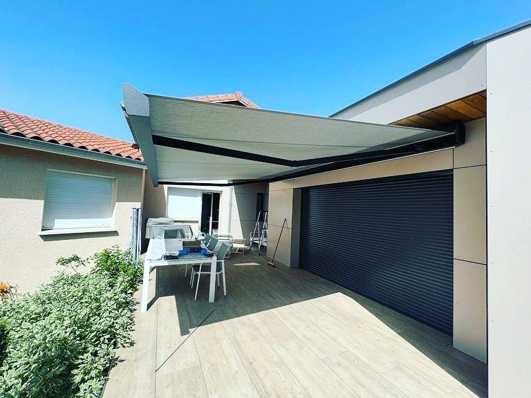Un auvent rétractable de couleur claire était déployé au-dessus d'une terrasse.