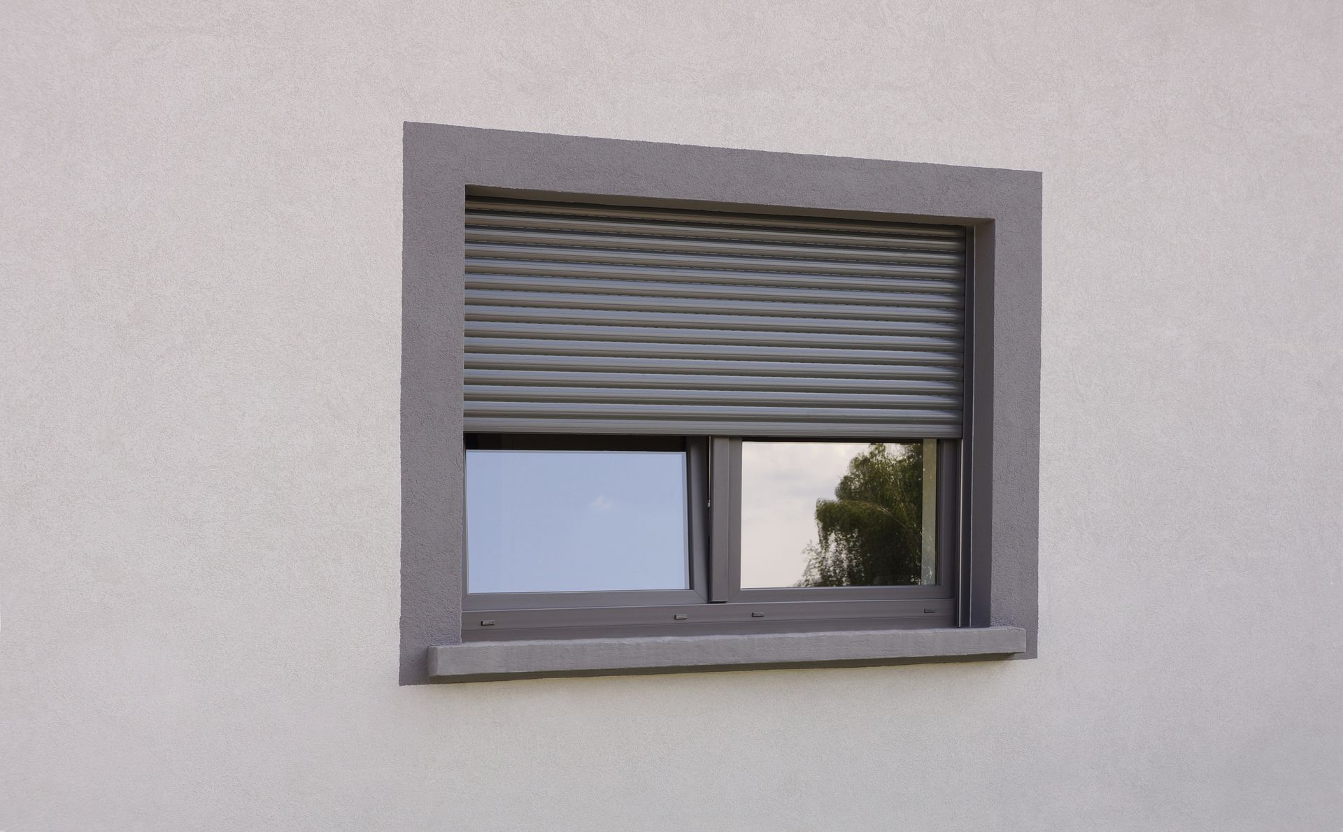Une fenêtre avec des volets roulants gris