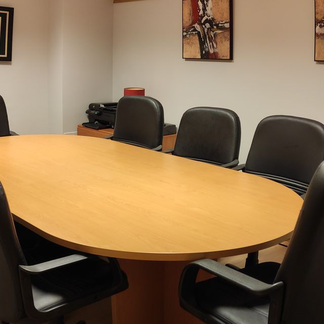 Una sala de conferencias con una mesa grande y sillas