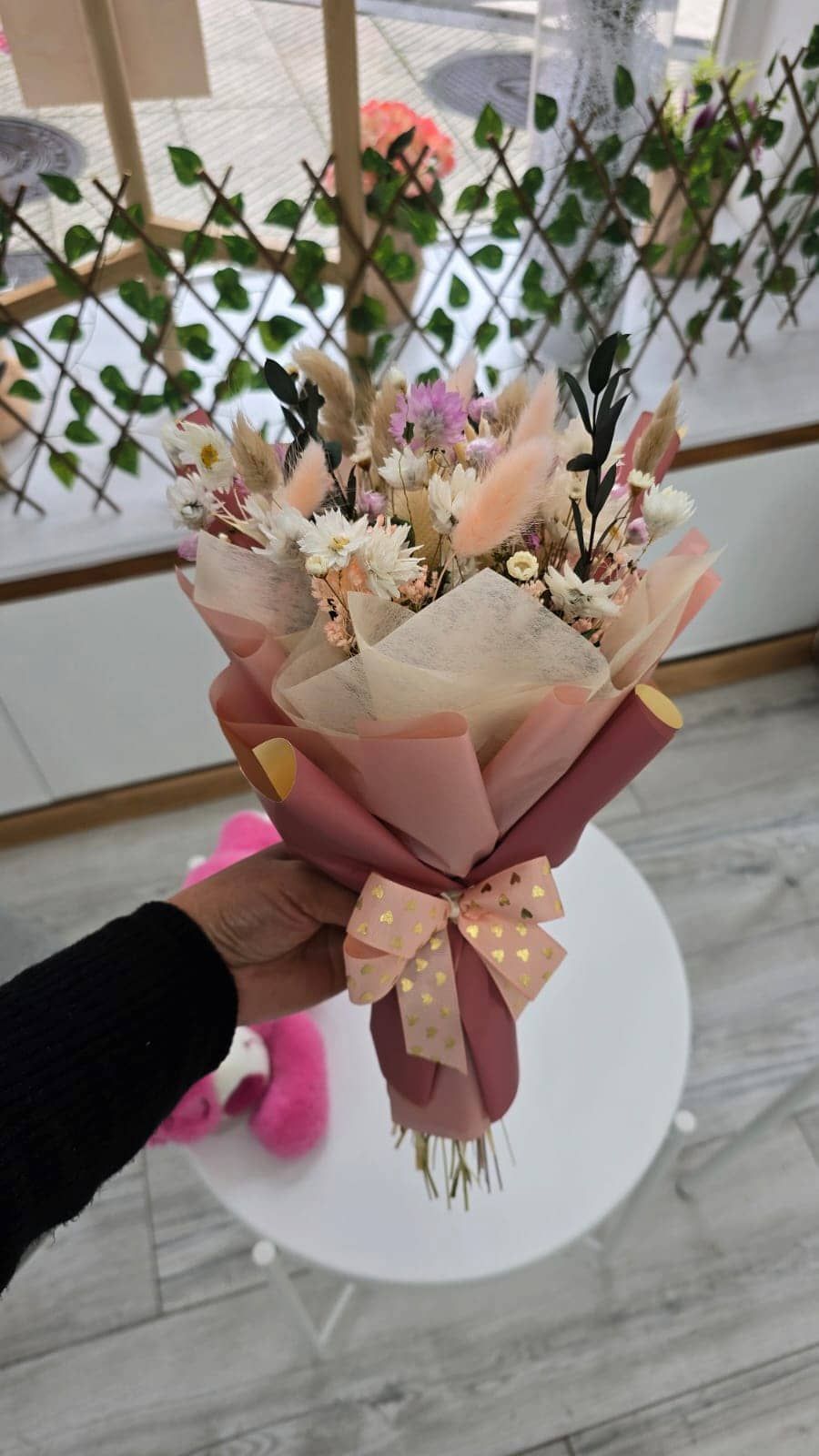 Persona colocando comida en una mesa, incluyendo queso y uvas. Blanco y negro.
