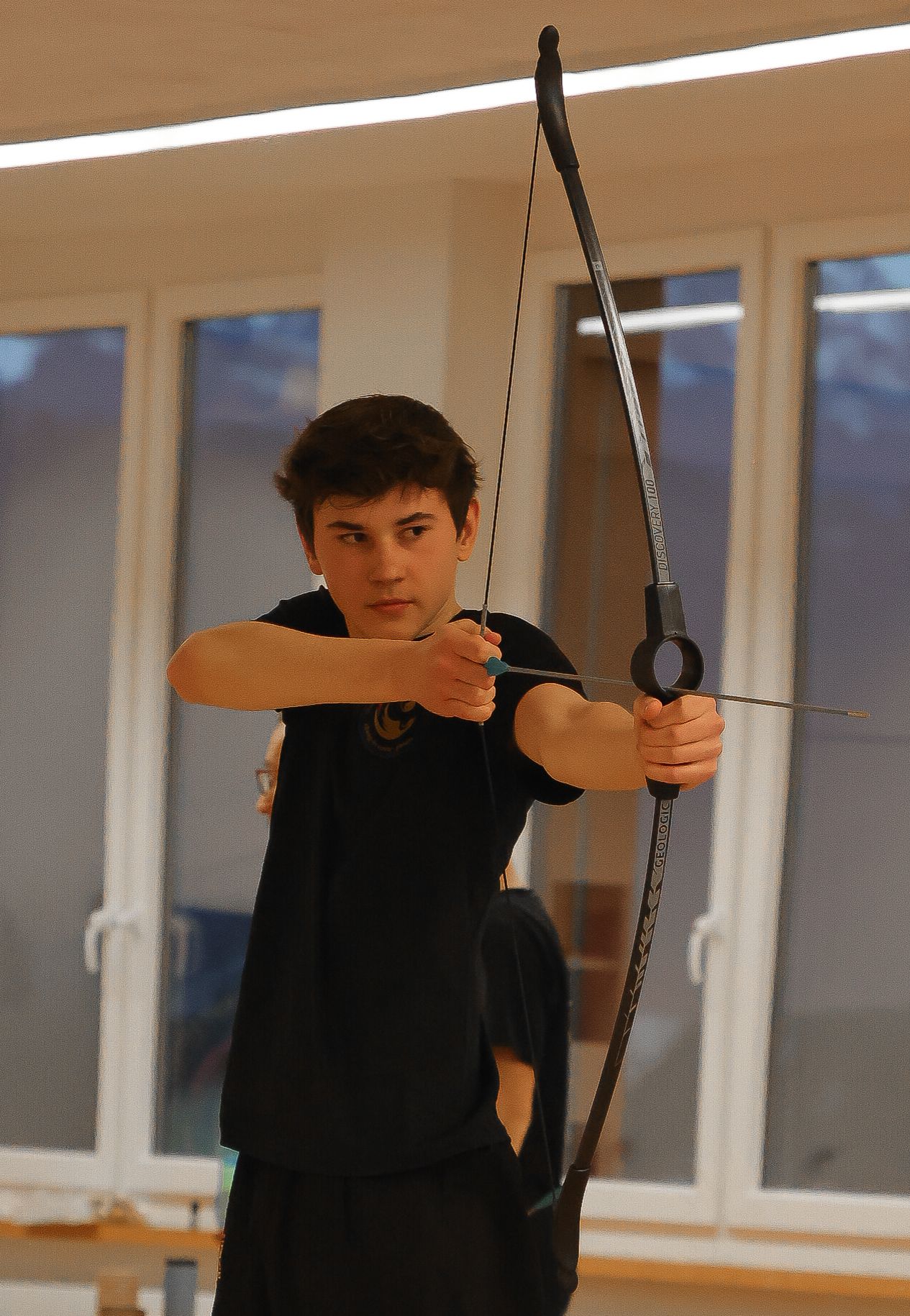 Jugendlicher beim Training mit einem Trainingsstab in der Sporthalle