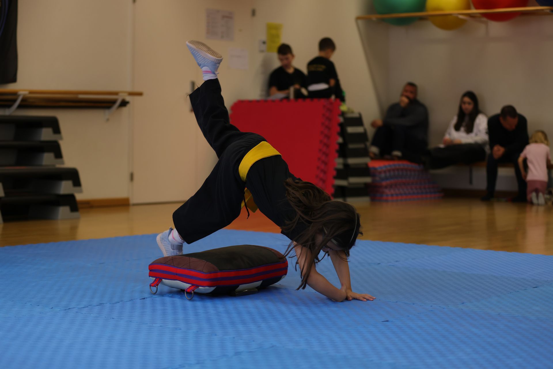 Kinder üben Hapkido Fallrollen im Dojang