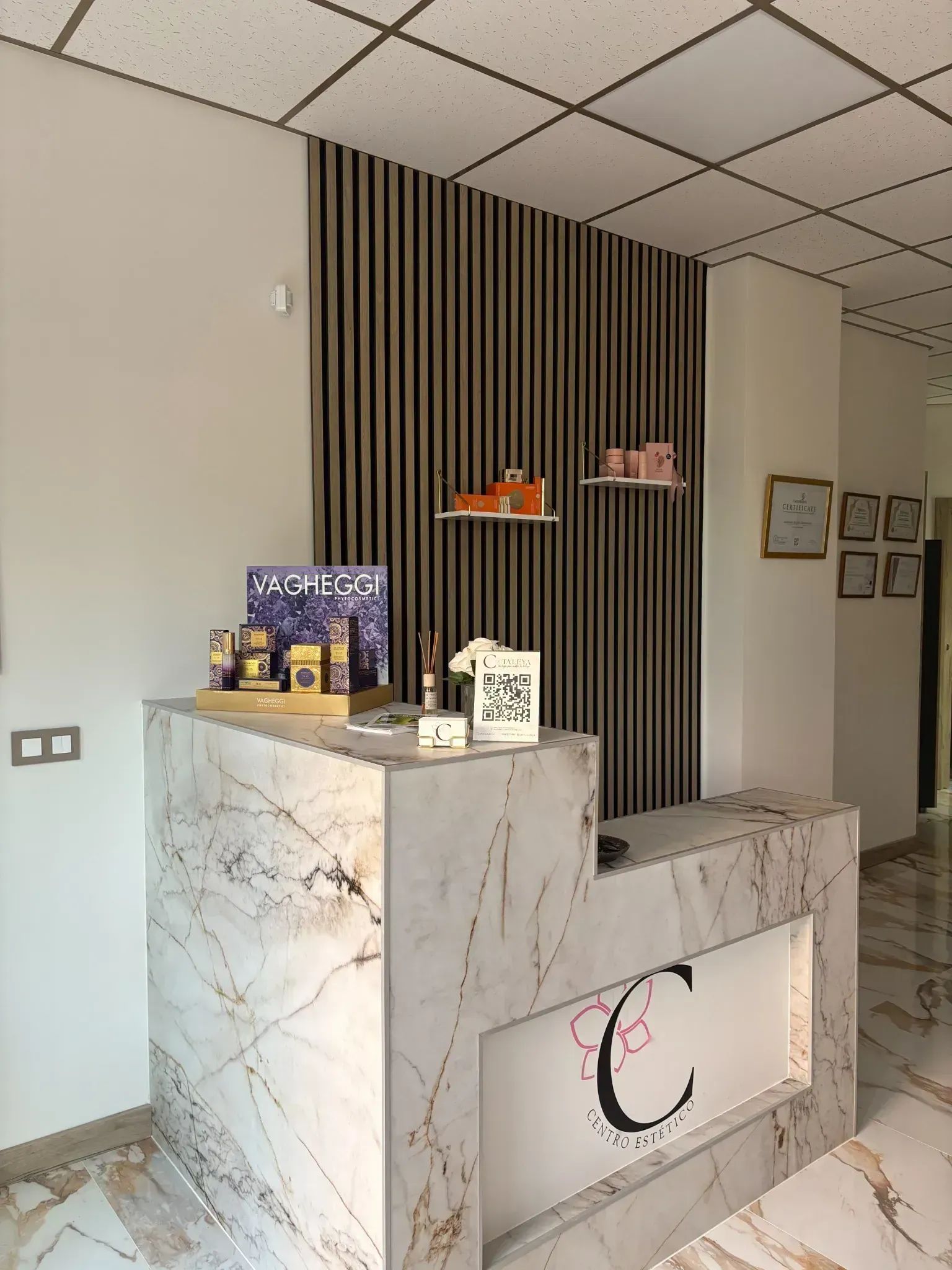 Mostrador de recepción de mármol en un vestíbulo moderno, con una pared decorativa a rayas