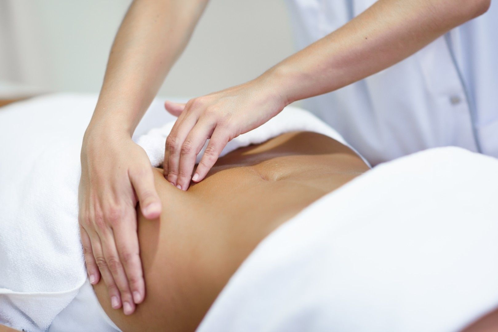 Manos masajeando la espalda de una persona durante un tratamiento de spa