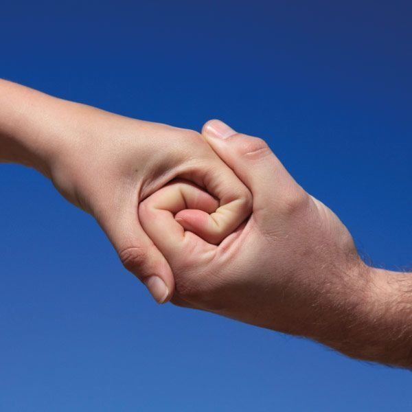 Manos unidas contra un cielo azul, formando un remolino.