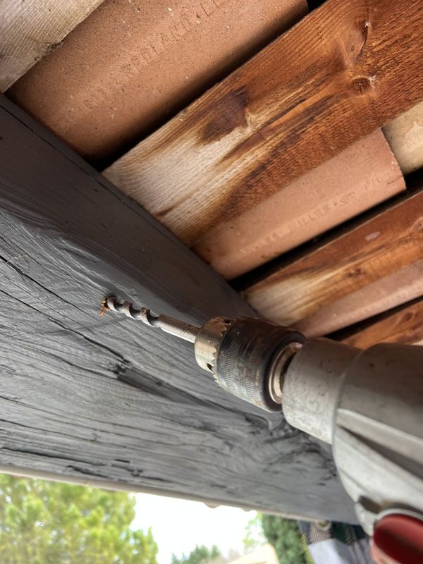 Perçage d'une poutre pour appliquer un traitement protecteur