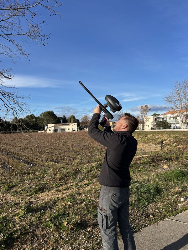 Un de nos techniciens qui tire une bille d'insecticide sur un nid de frelons à l'aide d'un pistolet