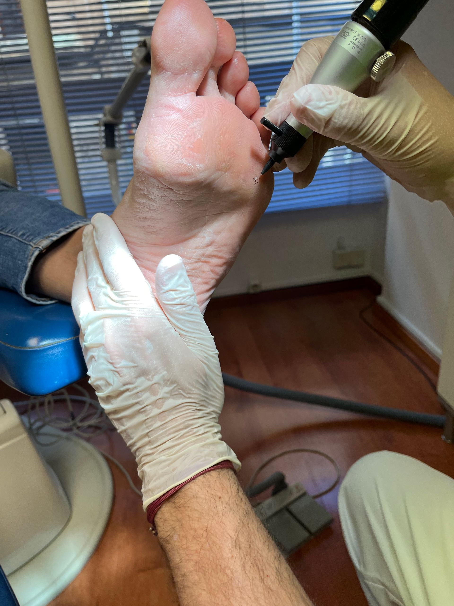 Una persona se está haciendo examinar el pie por un médico.