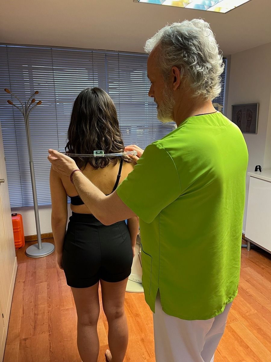 Un hombre con una camisa verde está midiendo la espalda de una mujer.