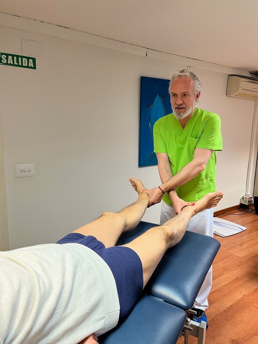Un hombre con una camisa verde le está dando un masaje a una persona.