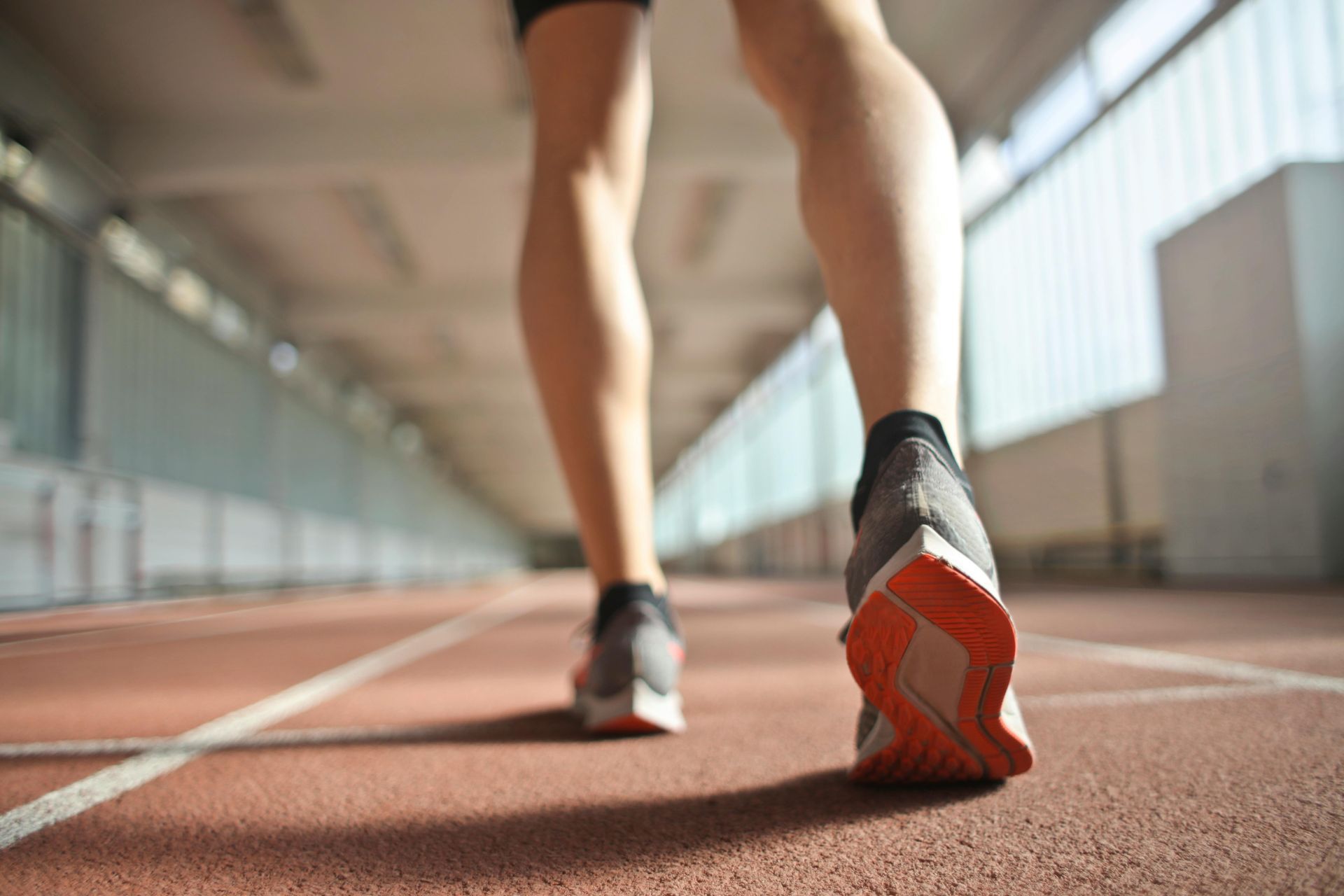 Una persona camina por una pista con zapatillas para correr.
