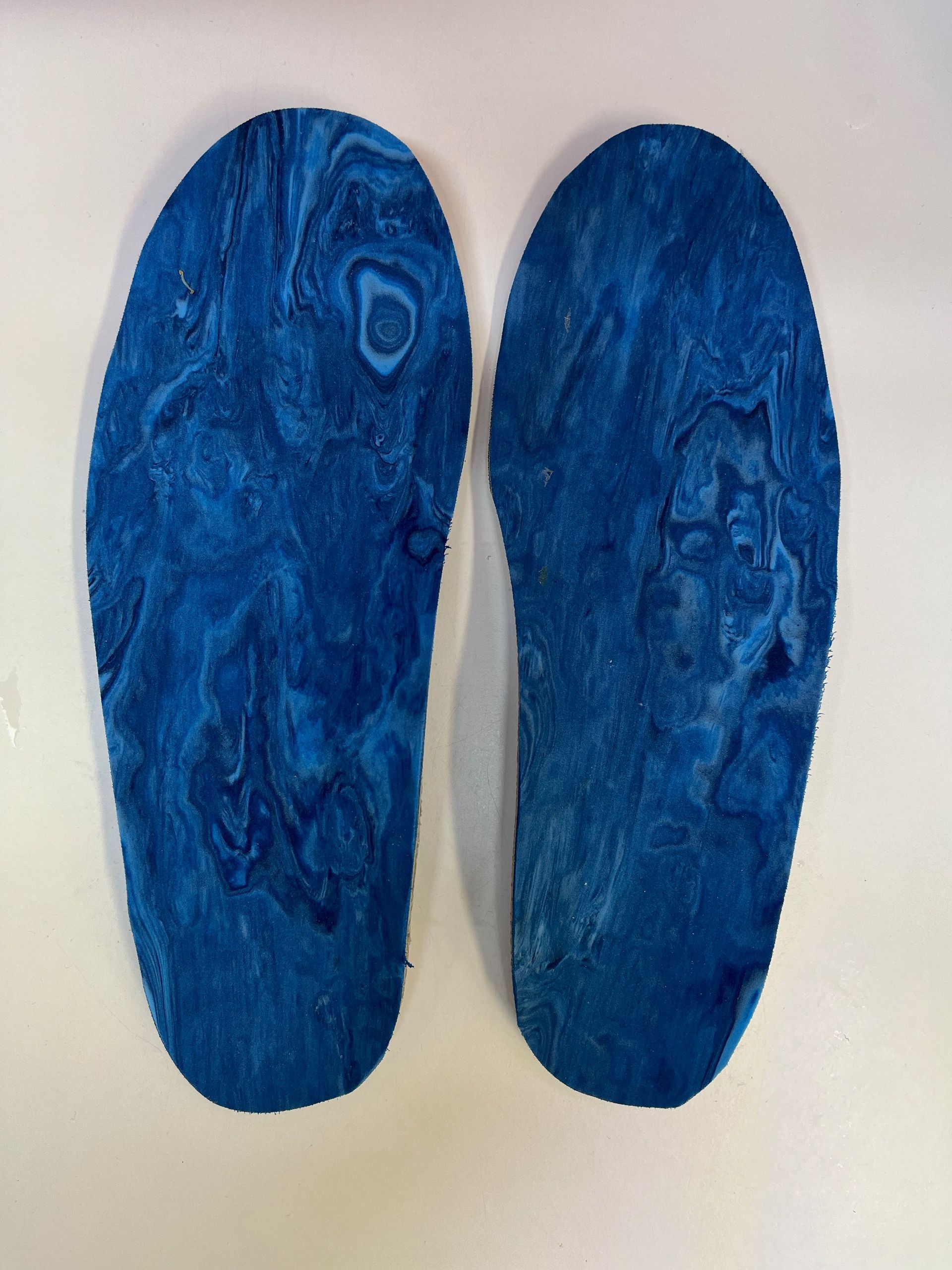 Un par de plantillas azules sobre una superficie blanca