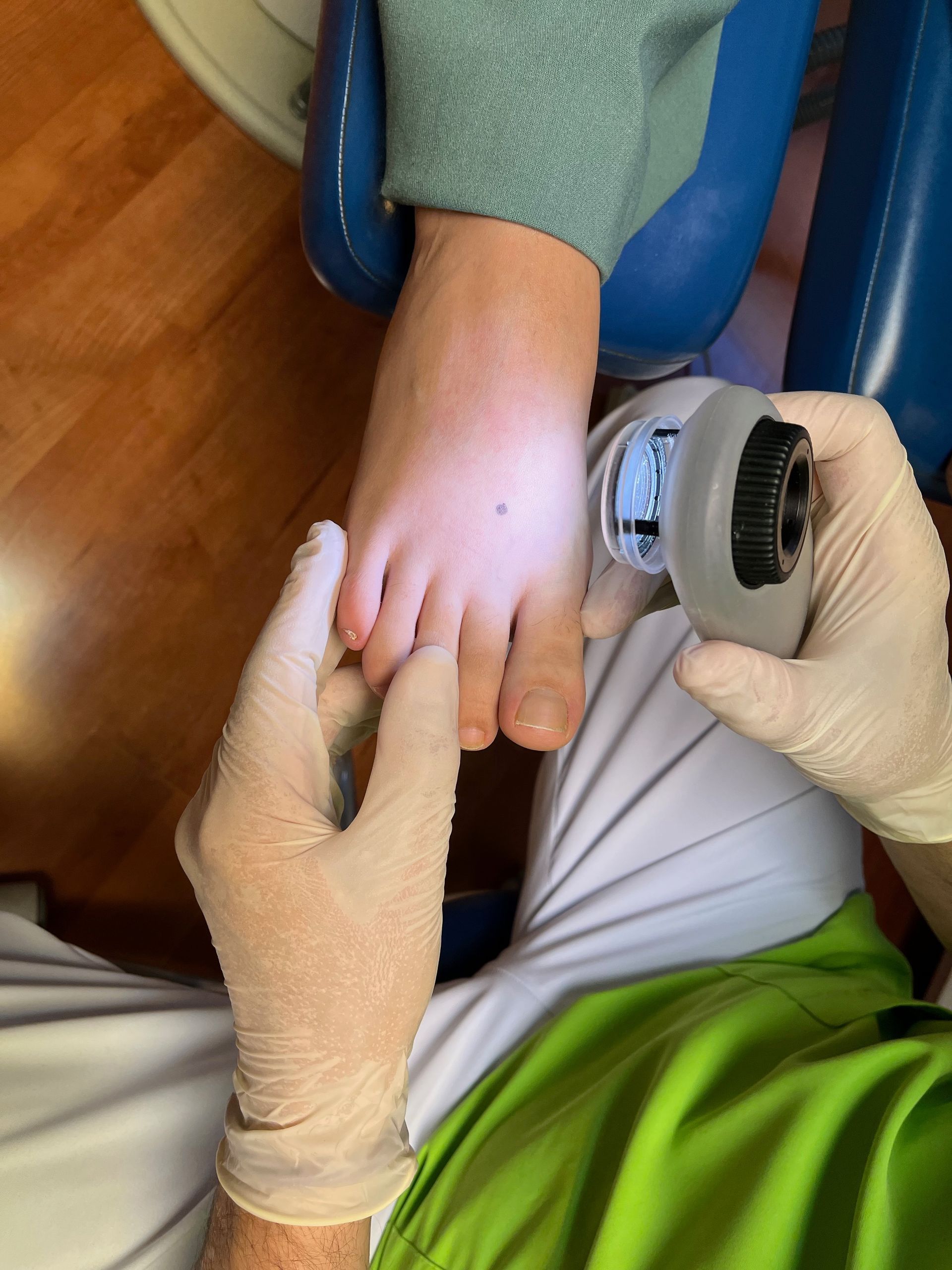 Un médico examina el pie de un niño con un microscopio.