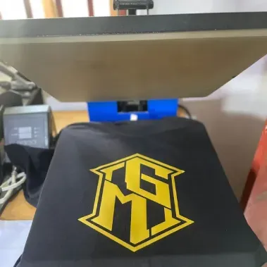 Capa de tecido preto com um logotipo geométrico amarelo para a base da impressora 3D