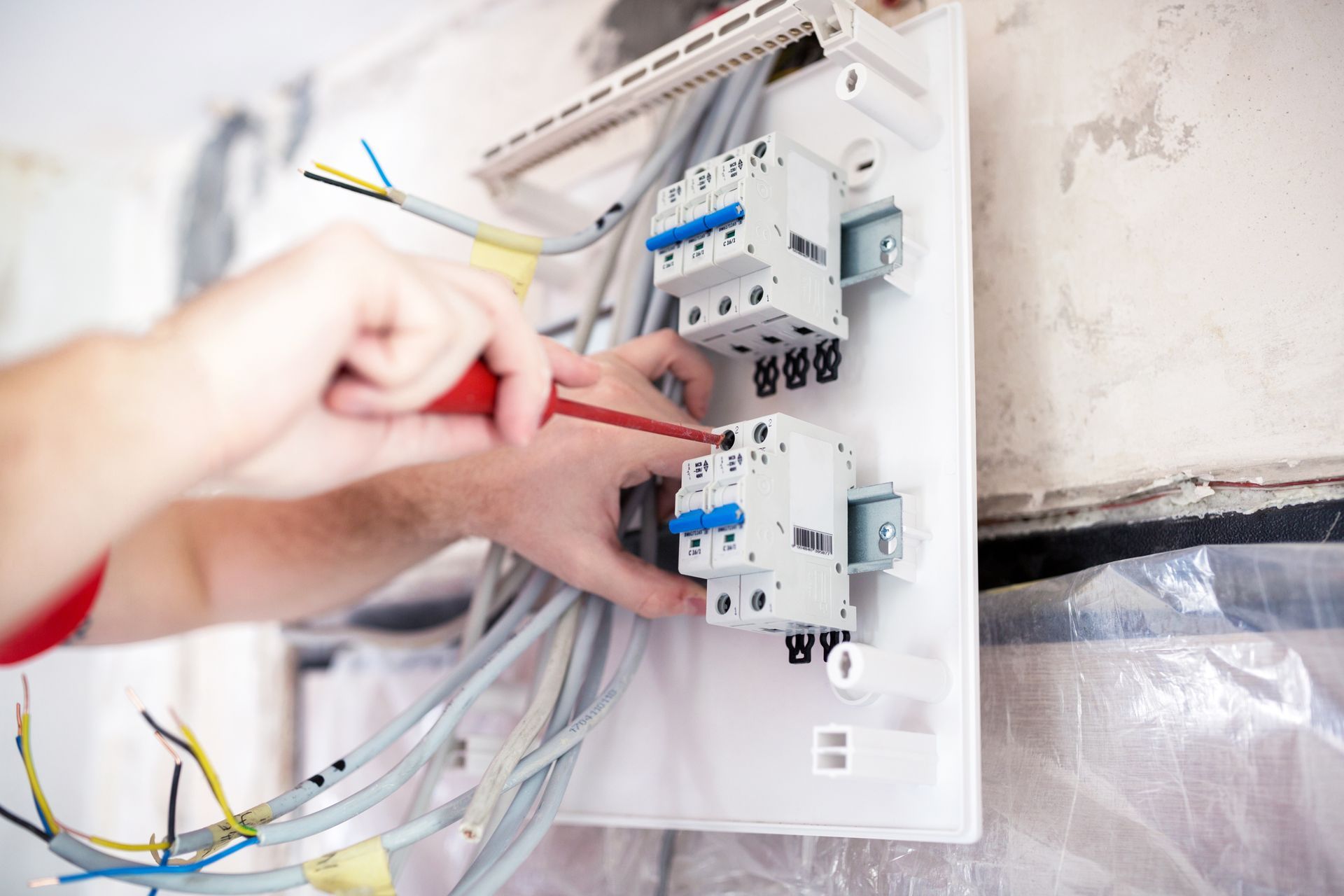 Un technicien effectue le câblage d'un tableau électrique.
