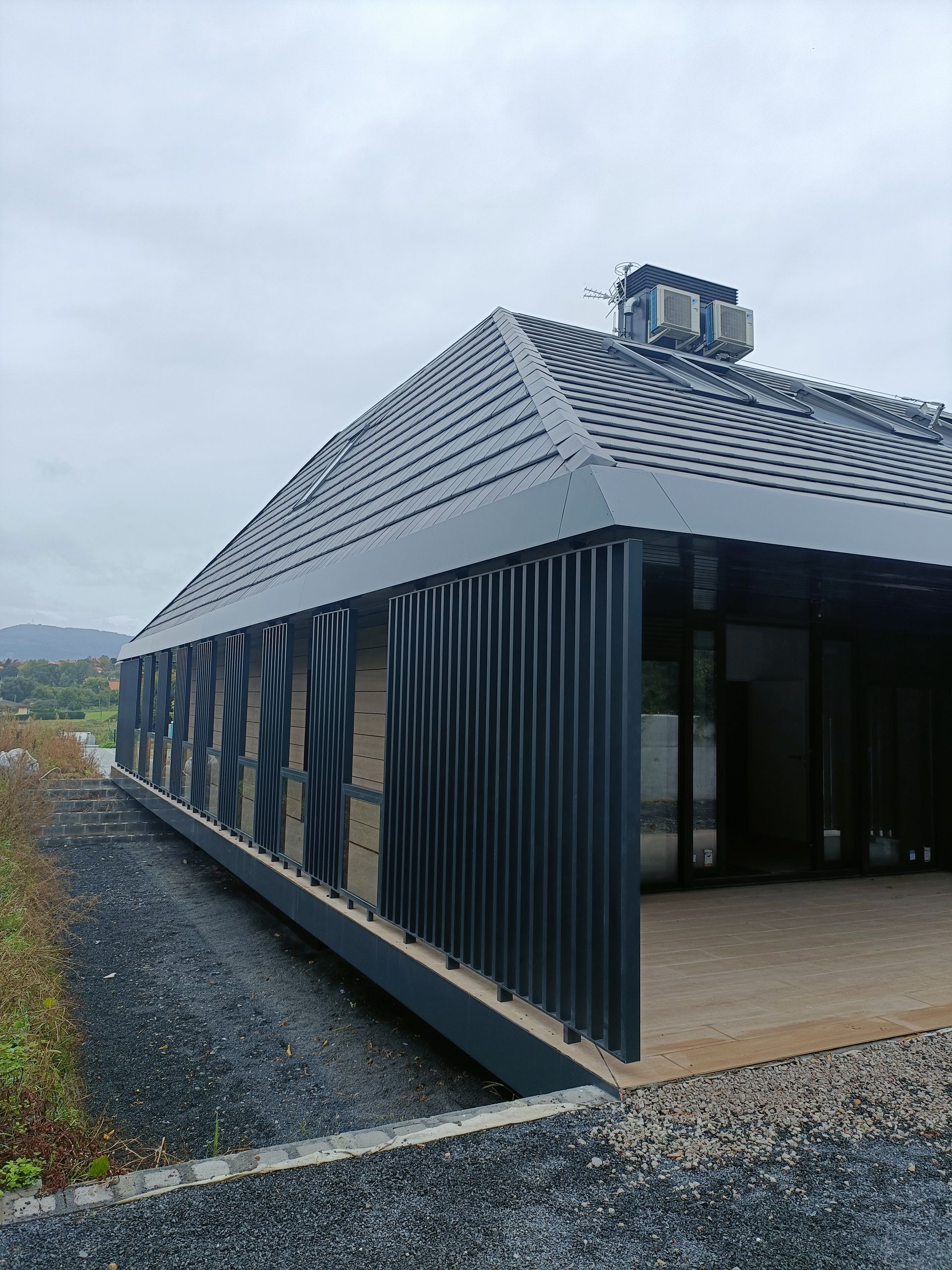 Un edificio muy largo con techo y muchas ventanas.