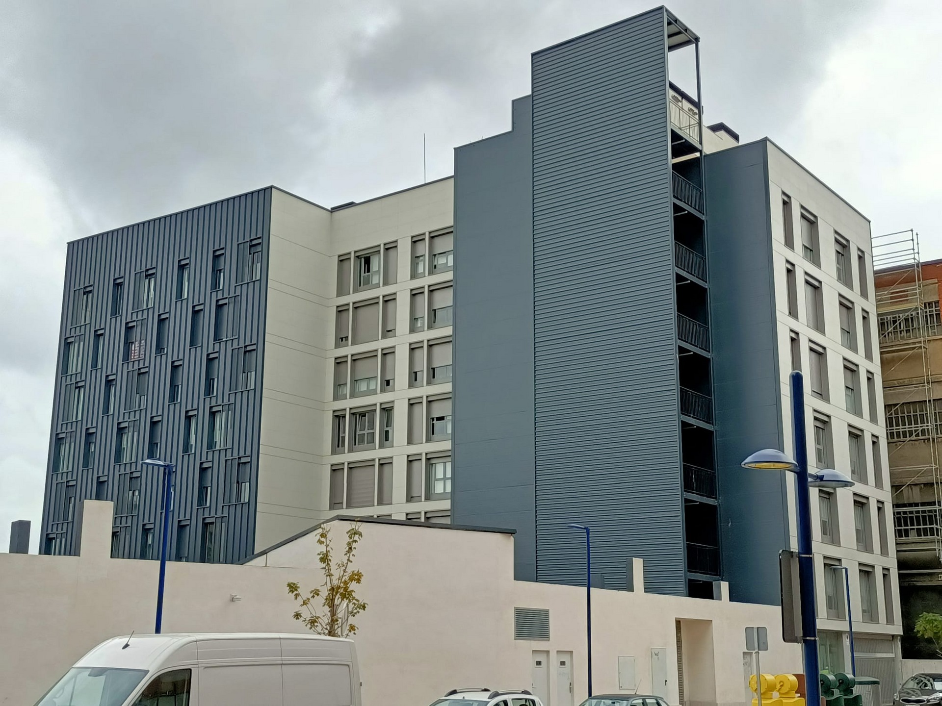 Una camioneta blanca está estacionada frente a un gran edificio.