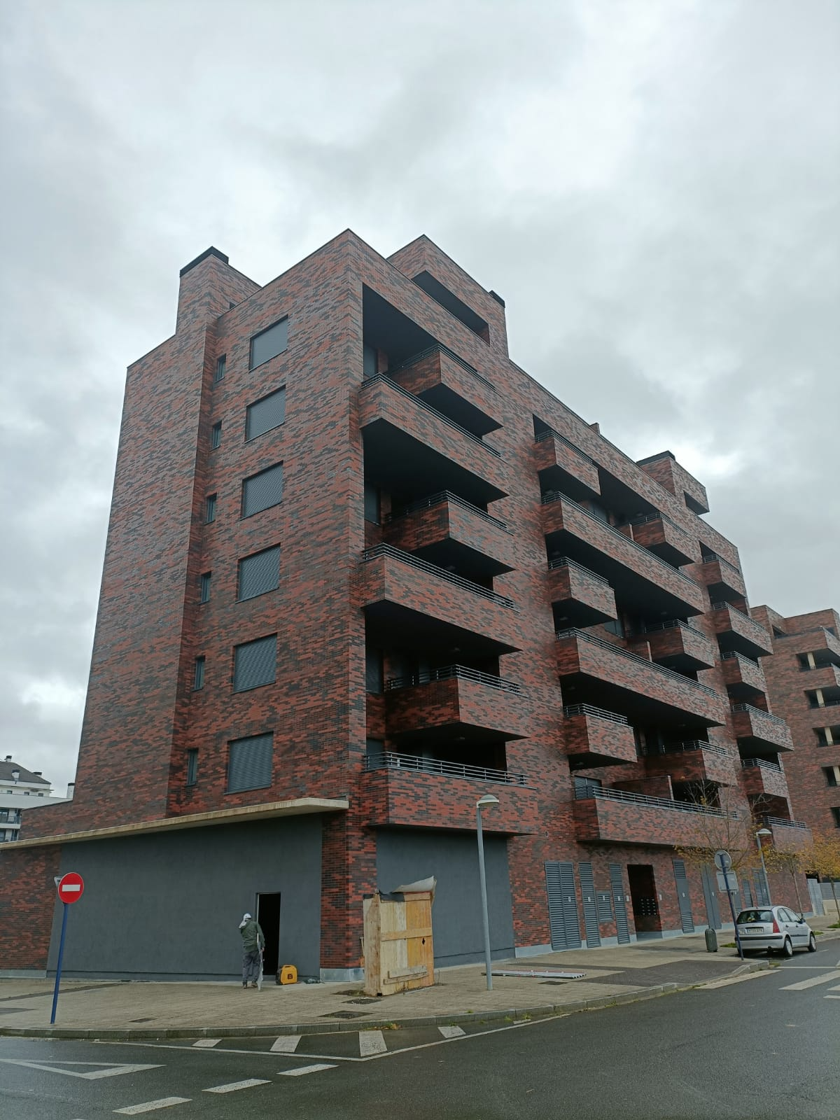 Un gran edificio de ladrillo con muchos balcones en un día nublado.