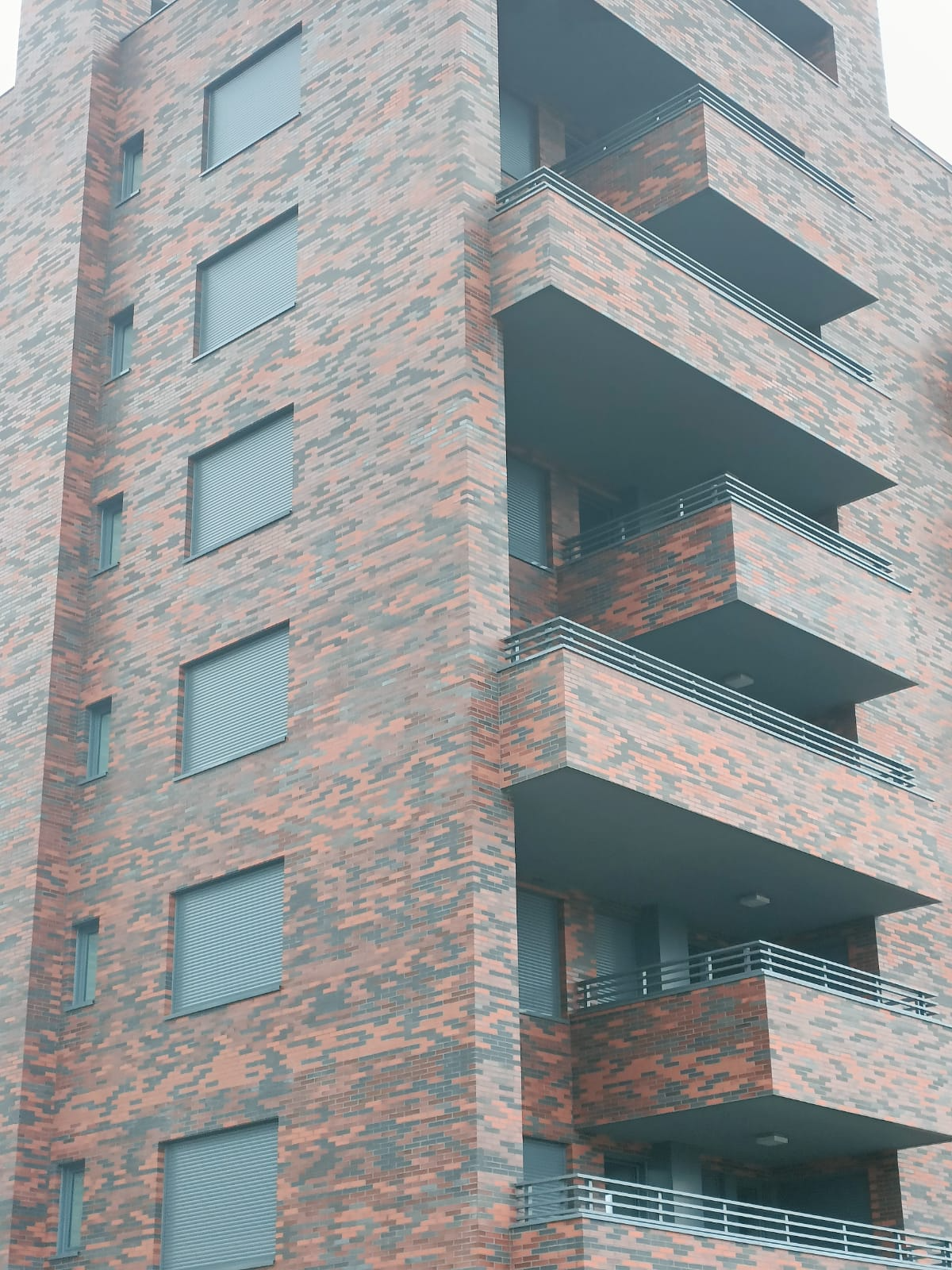 Un edificio alto de ladrillo con muchas ventanas y balcones.