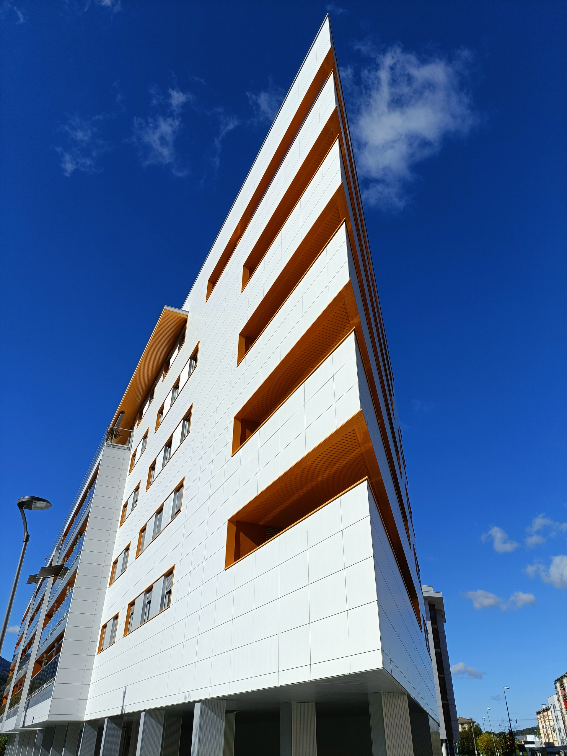 Un edificio alto y blanco con un cielo azul al fondo.