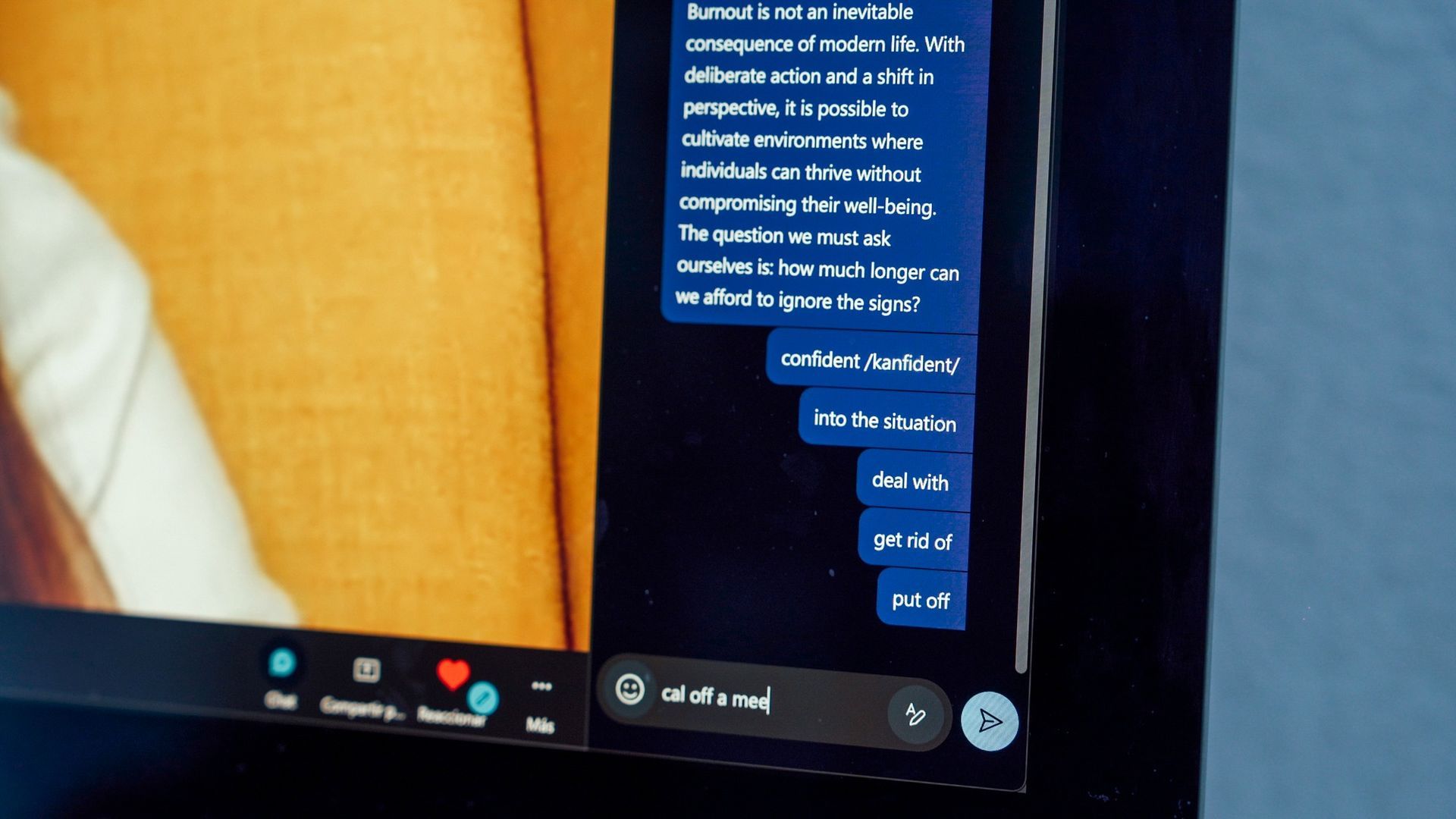 Ventana de chat en la pantalla de un portátil con burbujas de texto azules y una barra de herramientas