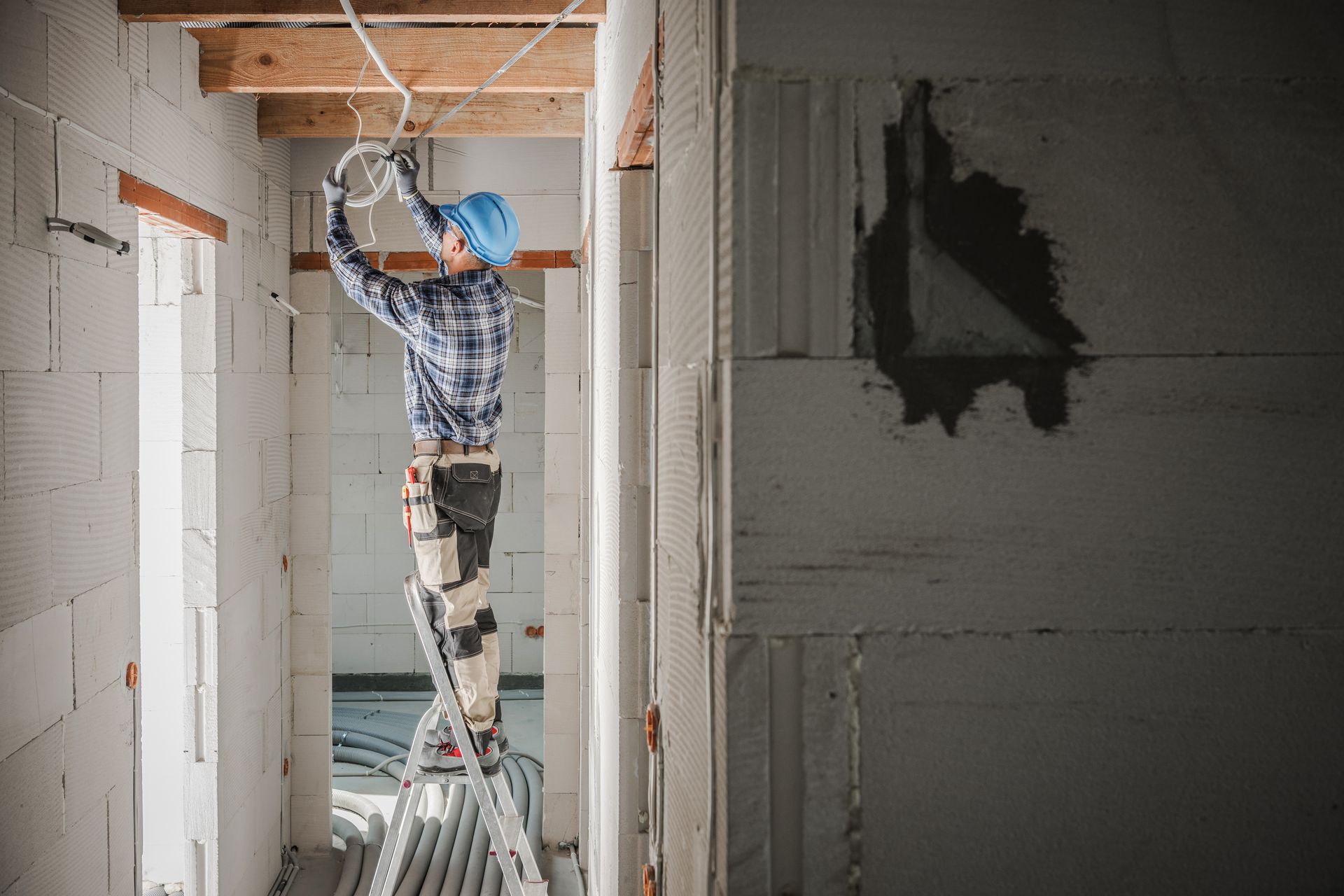 Un électricien dans une maison en rénovation.