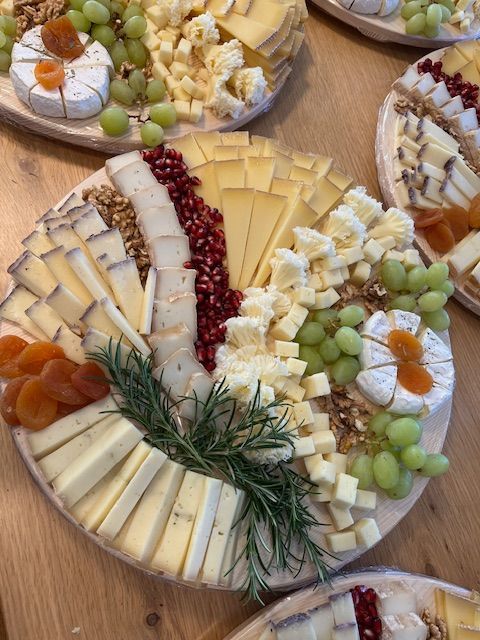 Une planche à découper en bois remplie de différents types de fromages et de fruits.