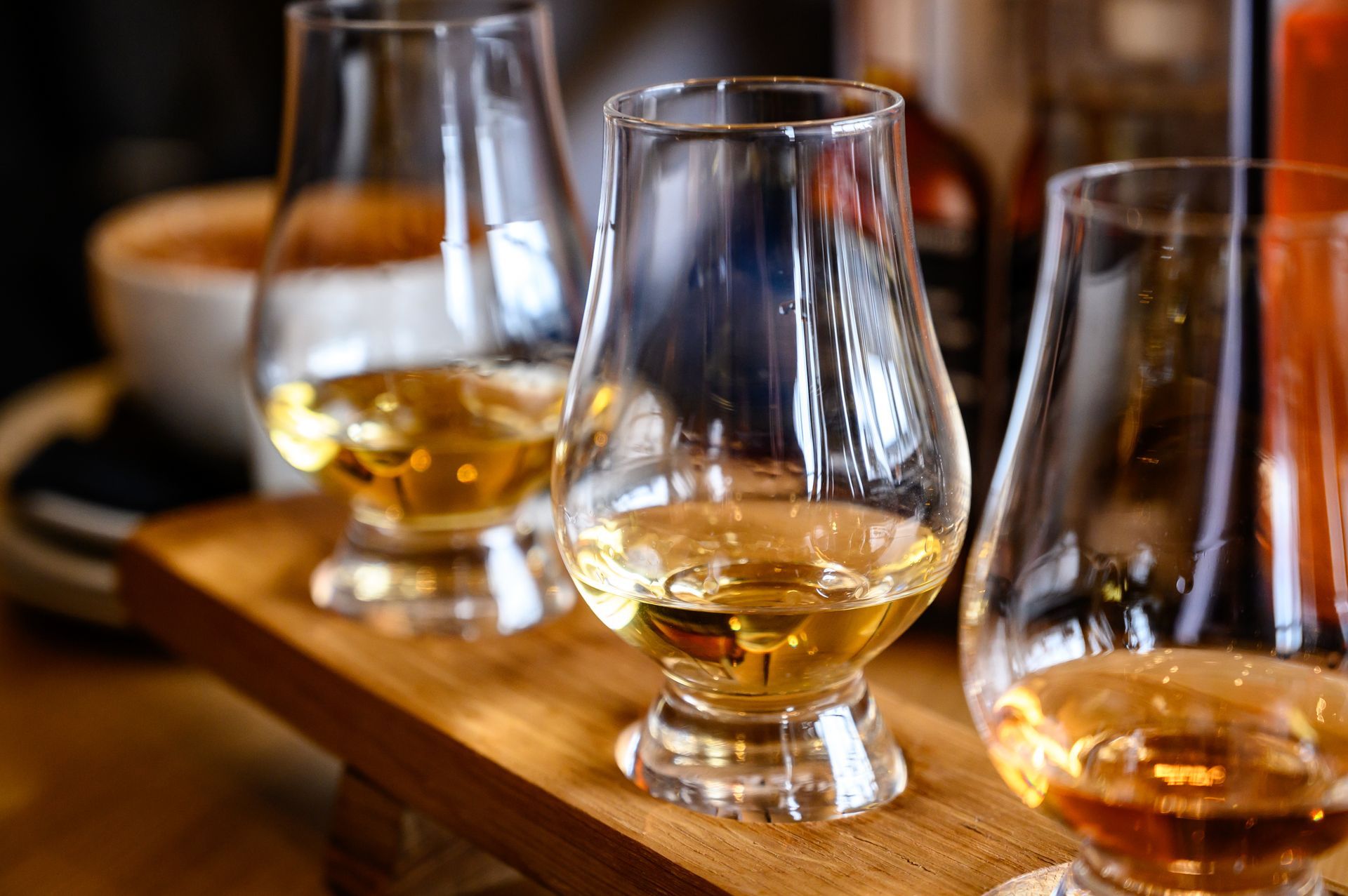 Trois verres de whisky sur une planche en bois