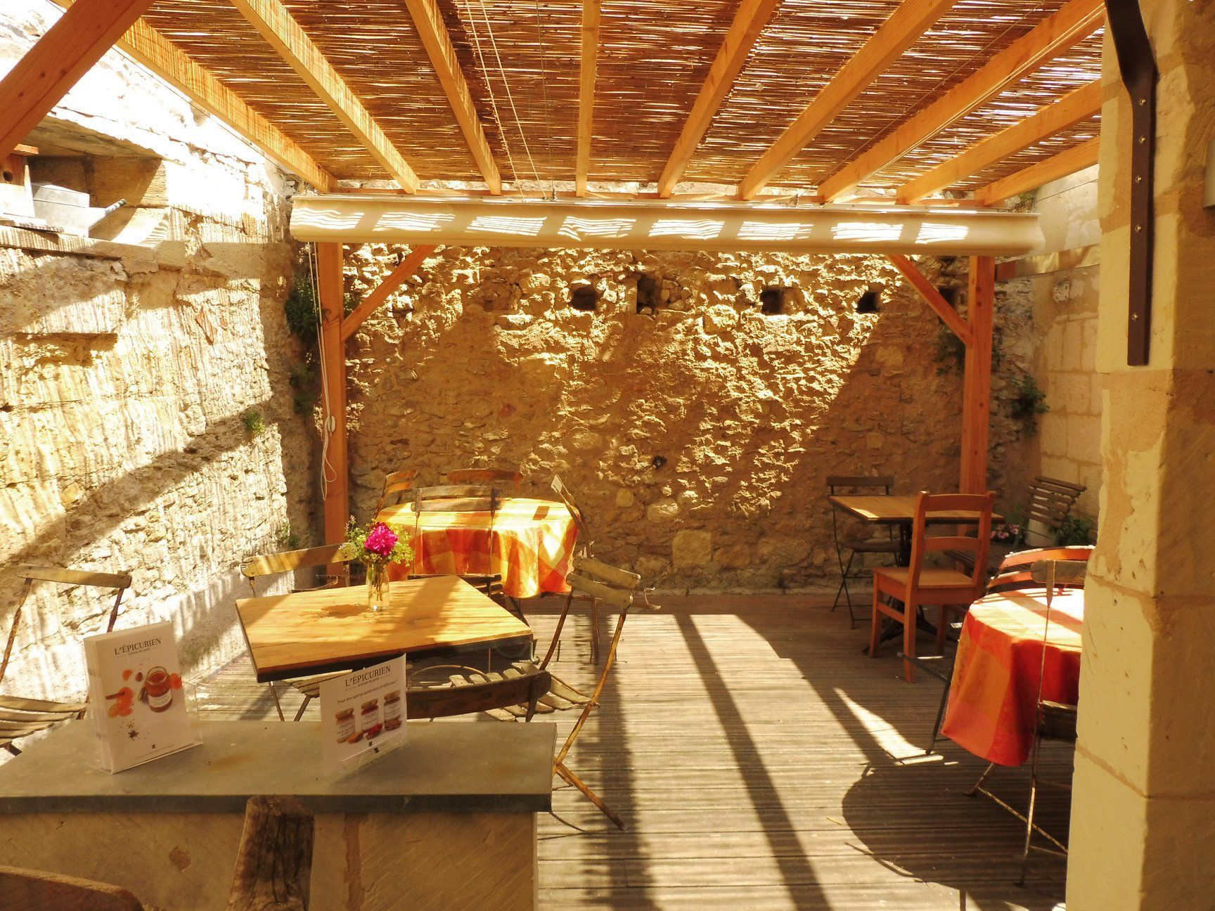 Une terrasse ensoleillée avec des murs en pierre