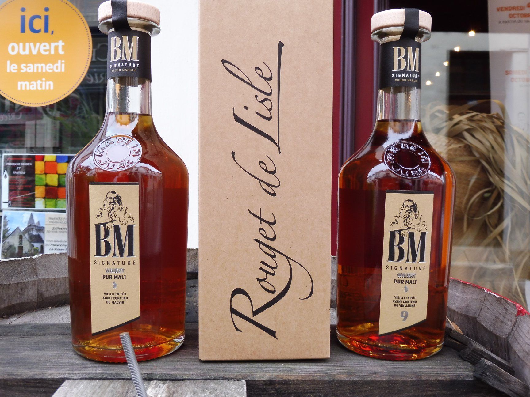 Deux bouteilles de whisky autour de leur carton d'emballage