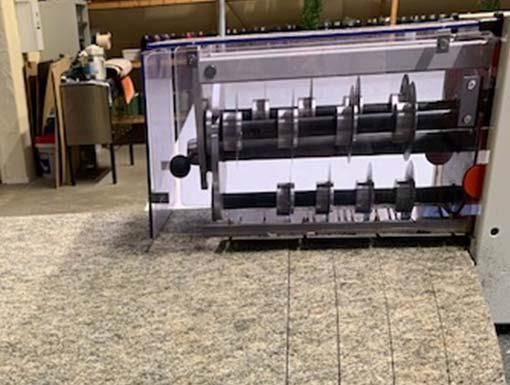 In einem Raum steht eine Maschine auf einem gefliesten Boden.