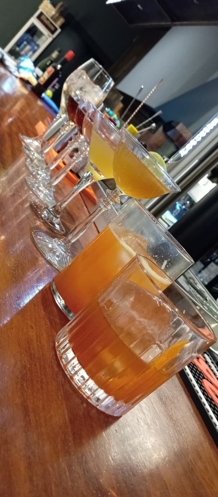 Una persona sostiene una botella de vino Beaujolais-Nouveau, cosecha de 1975, con una pared de ladrillos borrosa de fondo.