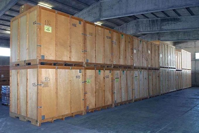 Zone de chargement ouverte du camion chargée de produits en bois arrimés par des cordes.