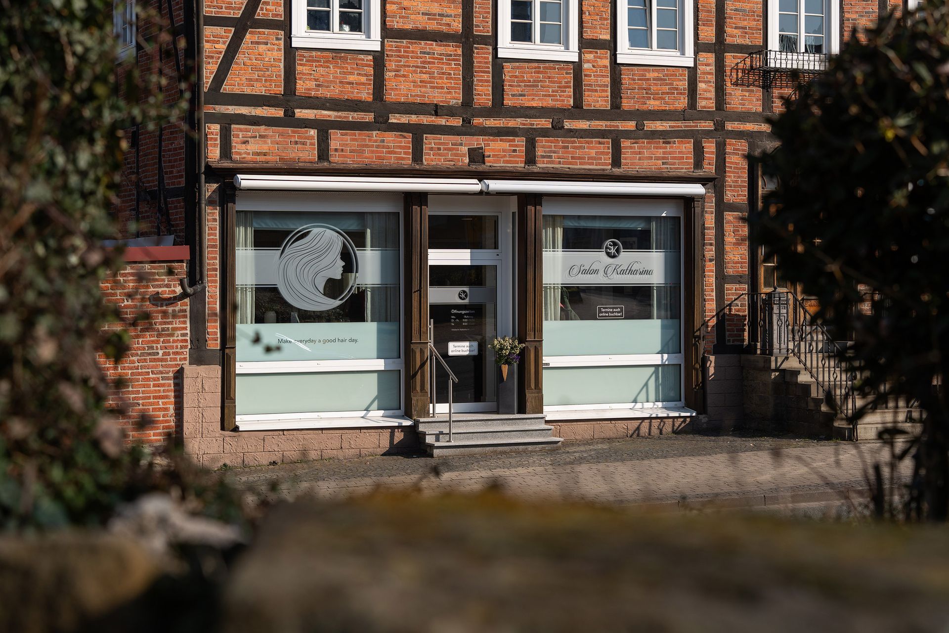 Ein Backsteingebäude mit einer Uhr an der Vorderseite Salon Katharina 