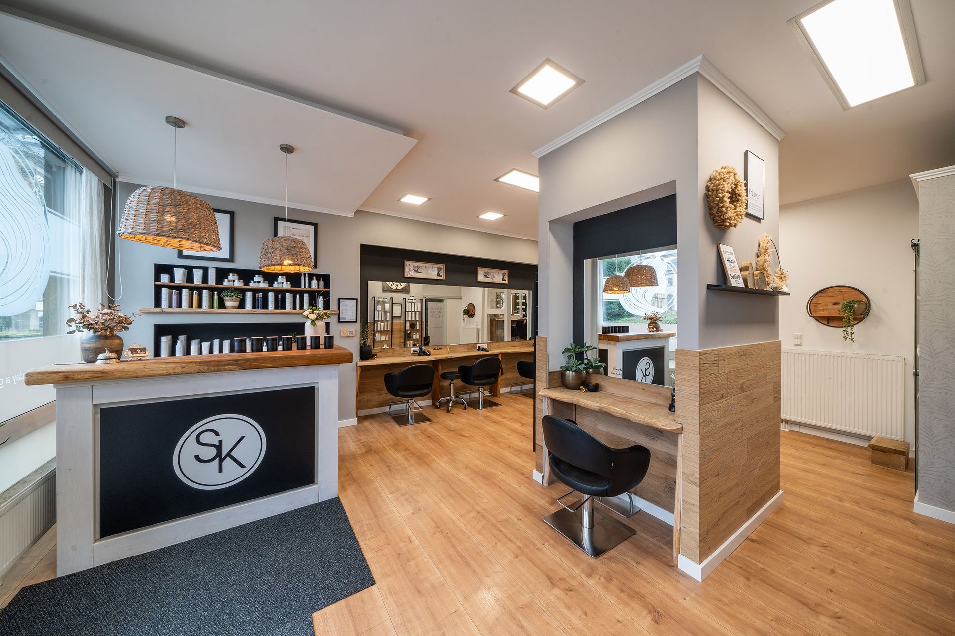 Das Innere eines Friseursalons mit Holzboden und einem Tresen Salon Katharina 