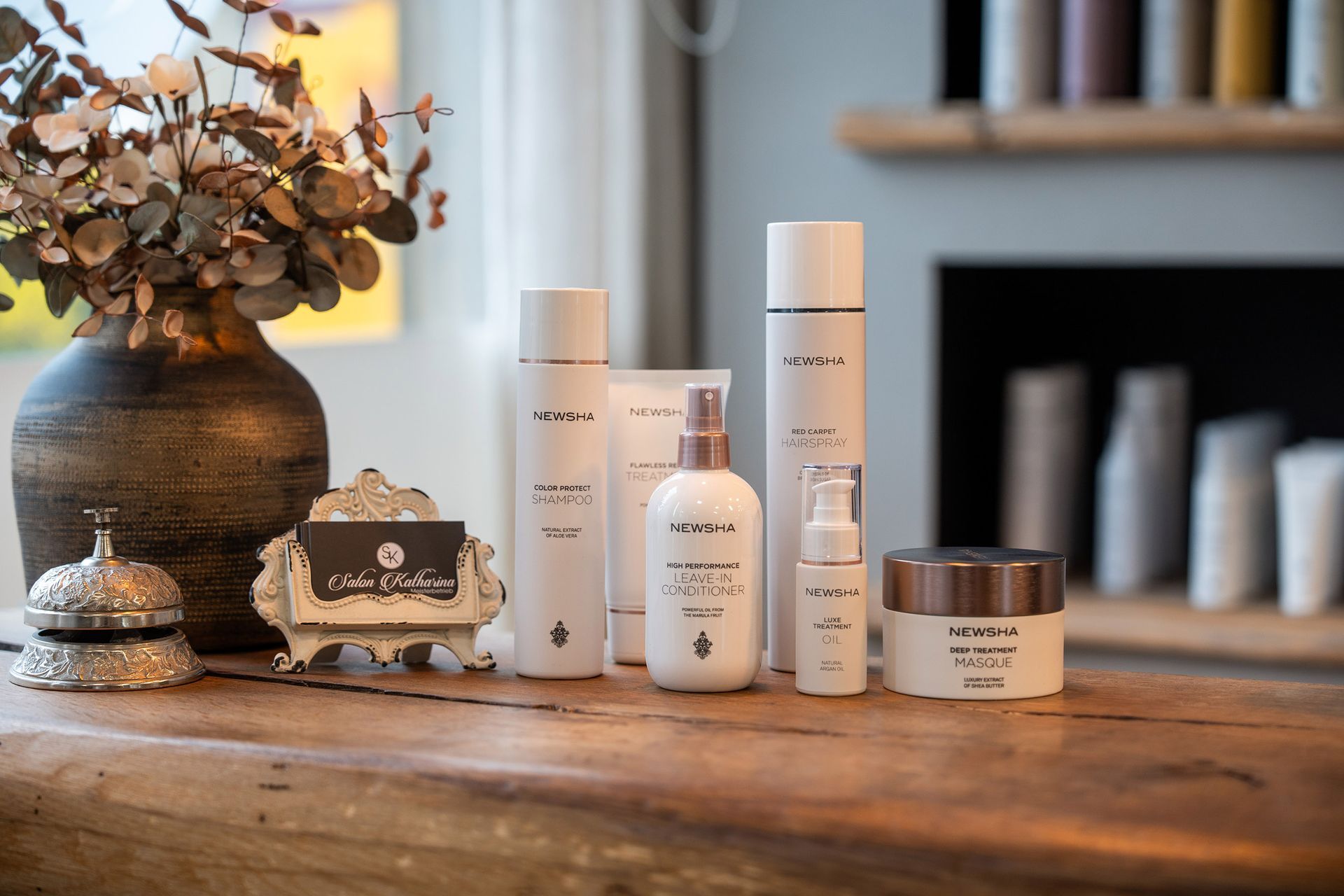 Auf einem Holztisch stehen mehrere Haarprodukte