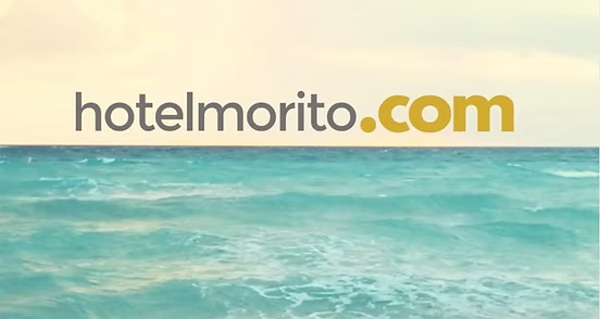 El texto "hotelmorito.com" en gris oscuro y dorado se sitúa sobre una tranquila vista al océano de color turquesa.
